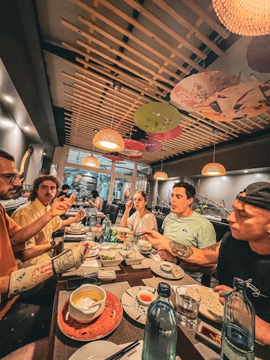 a group of people sitting around a table eating food