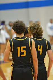 a group of young men standing next to each other on a basketball court