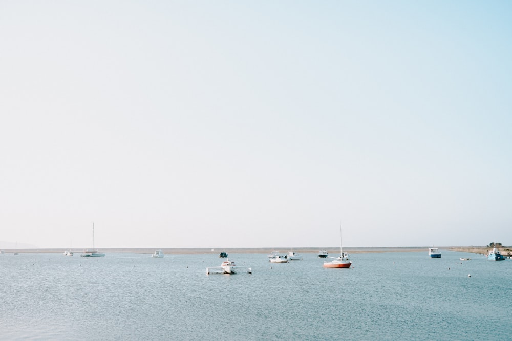 a group of boats floating on top of a large body of water