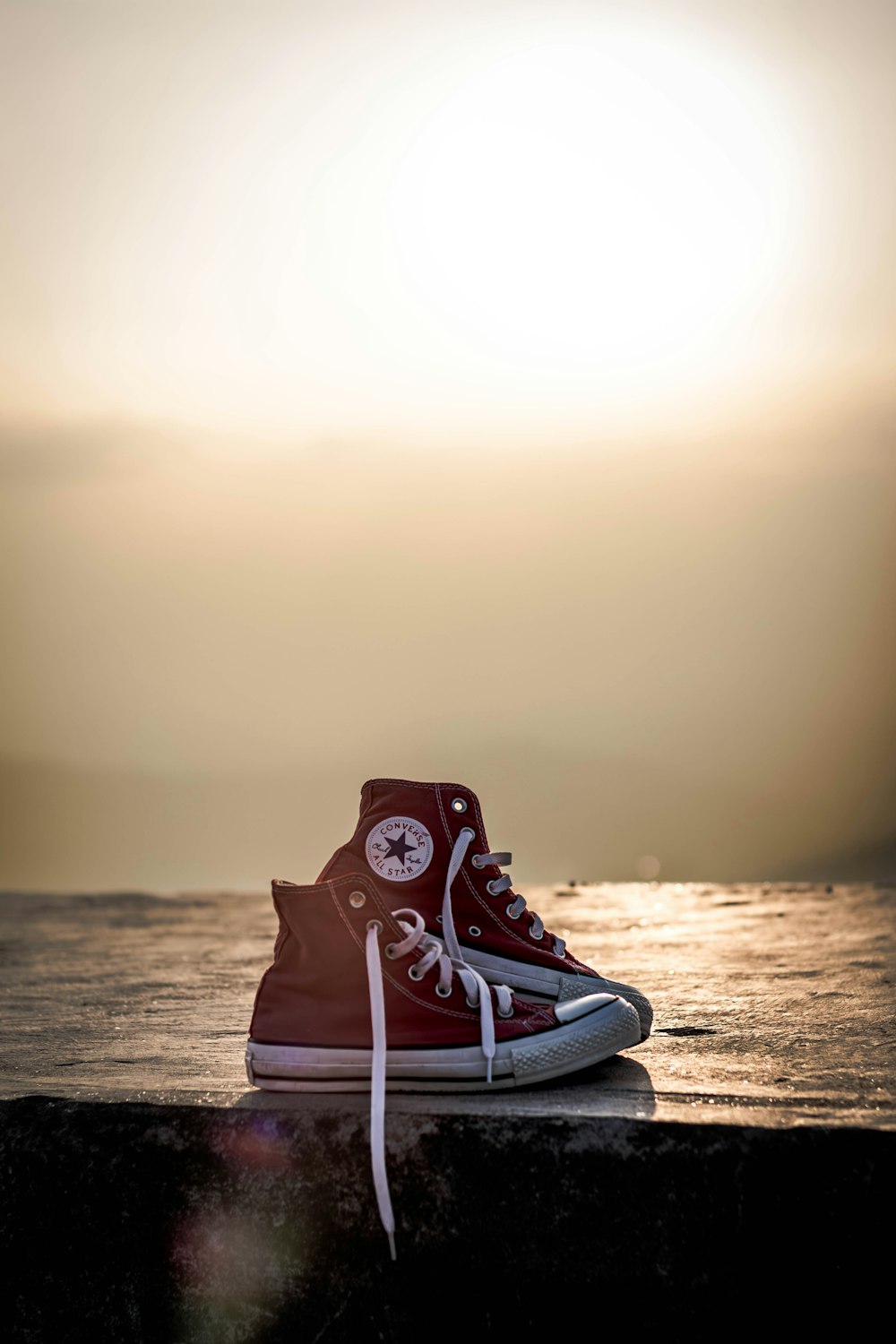 a pair of red and white sneakers sitting on a ledge