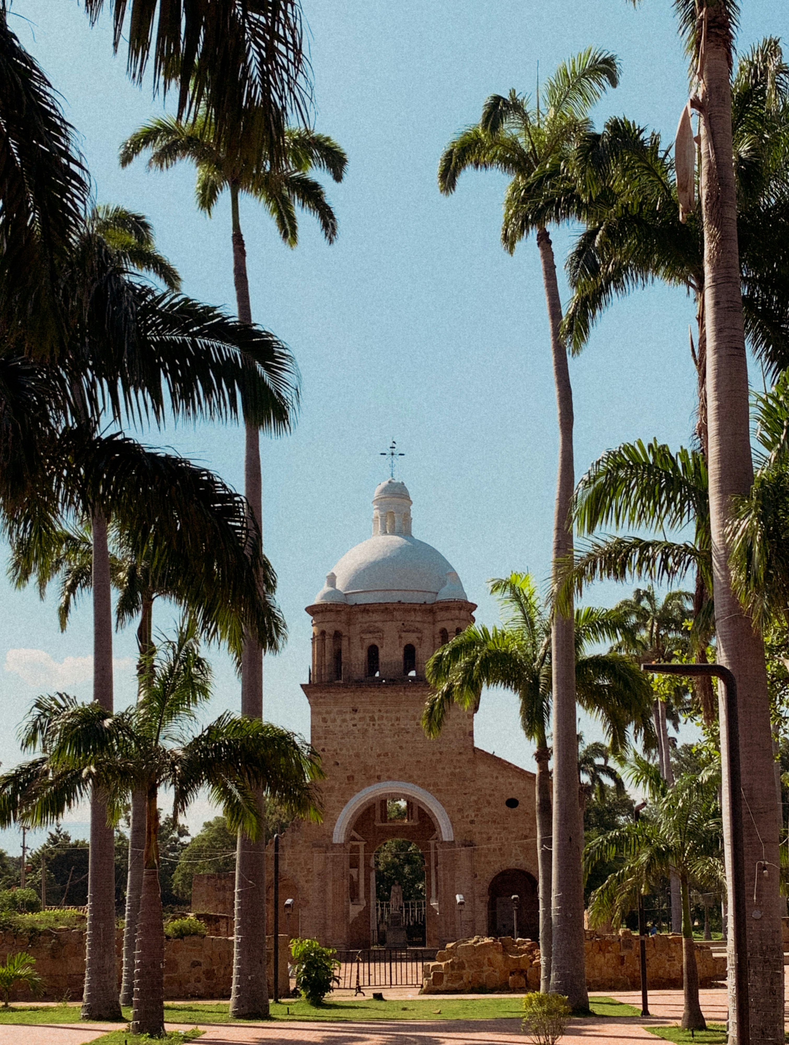 a church surrounded by palm trees on a sunny day