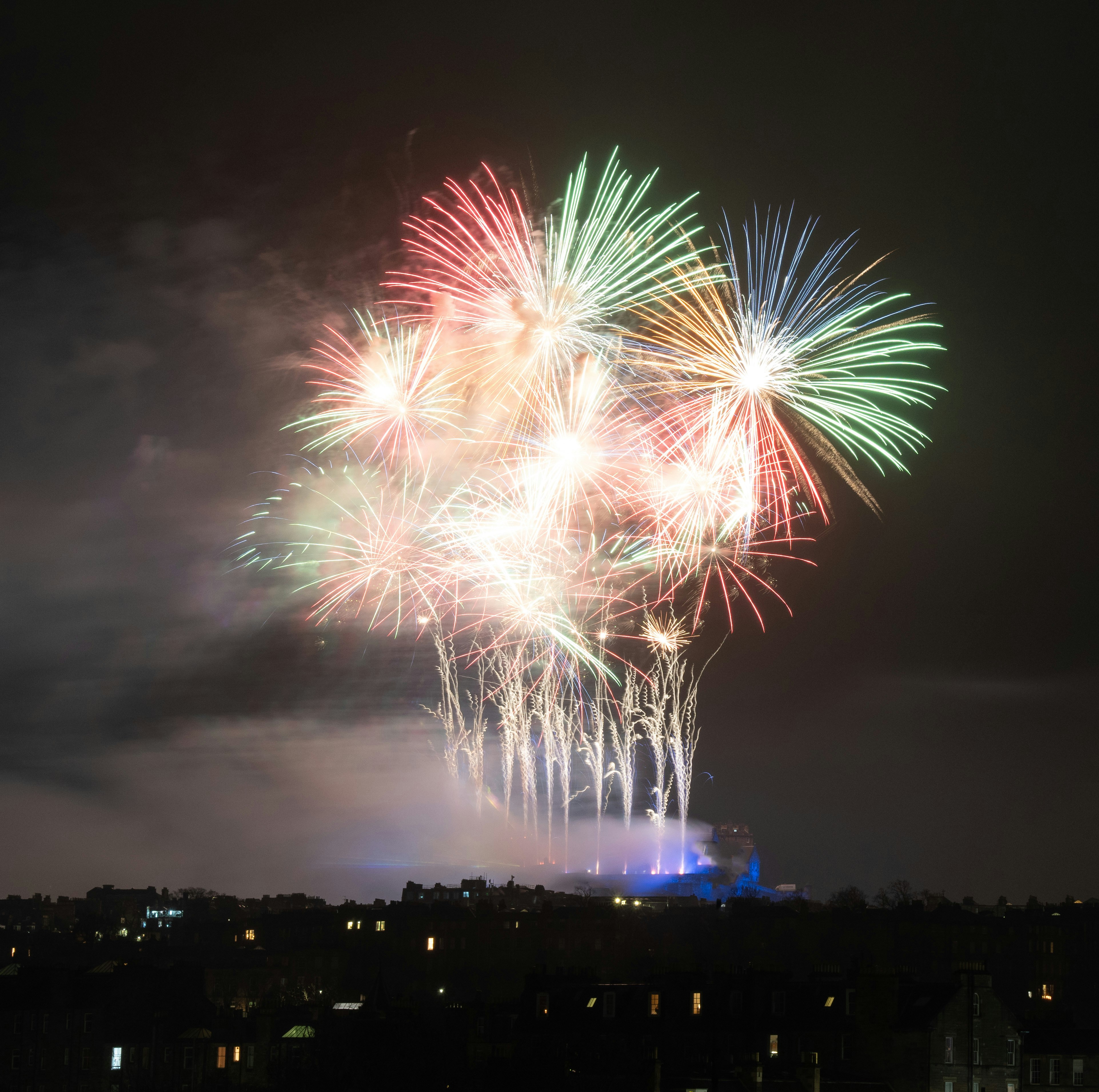 a group of fireworks are lit up in the night sky