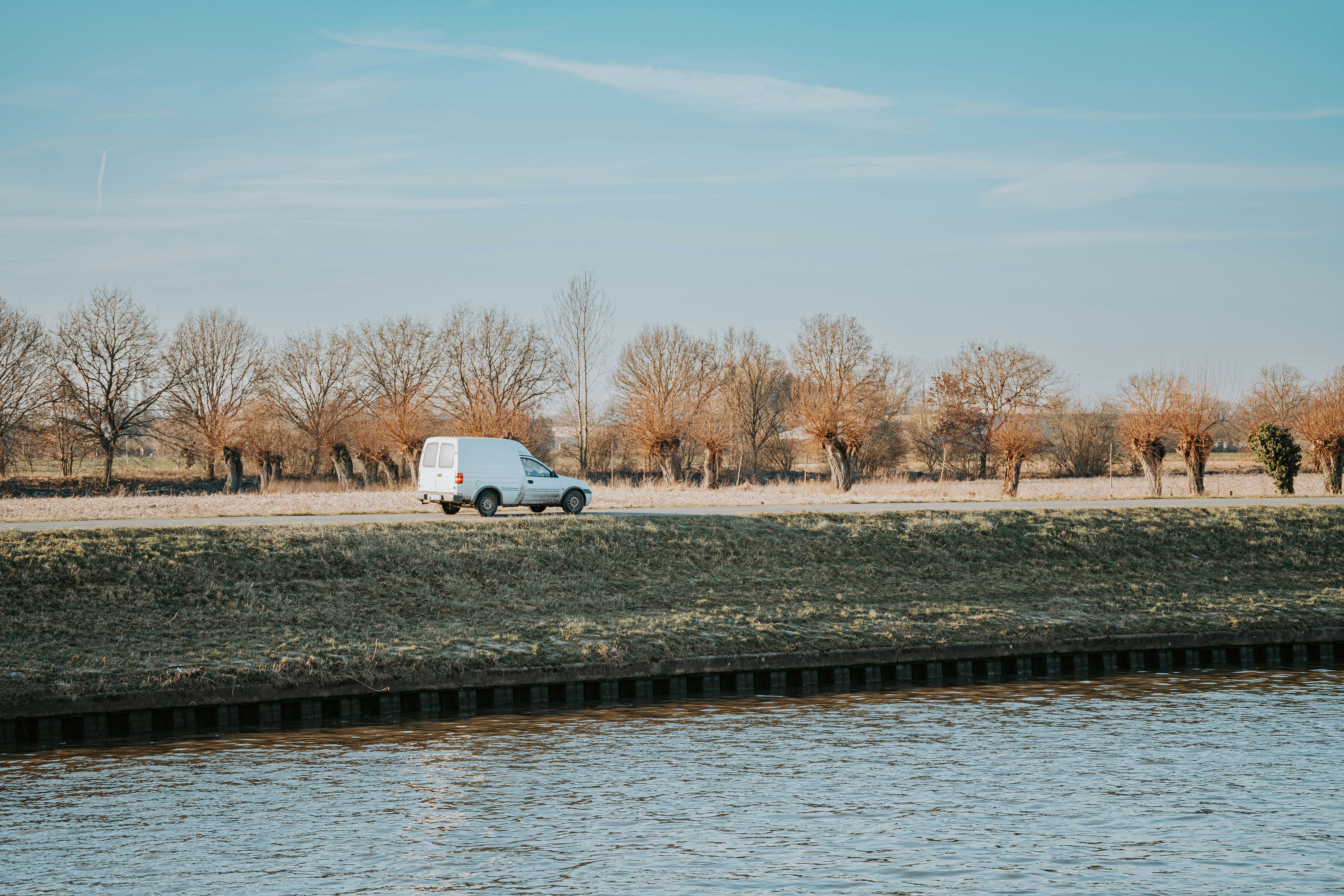 a van is parked next to a body of water