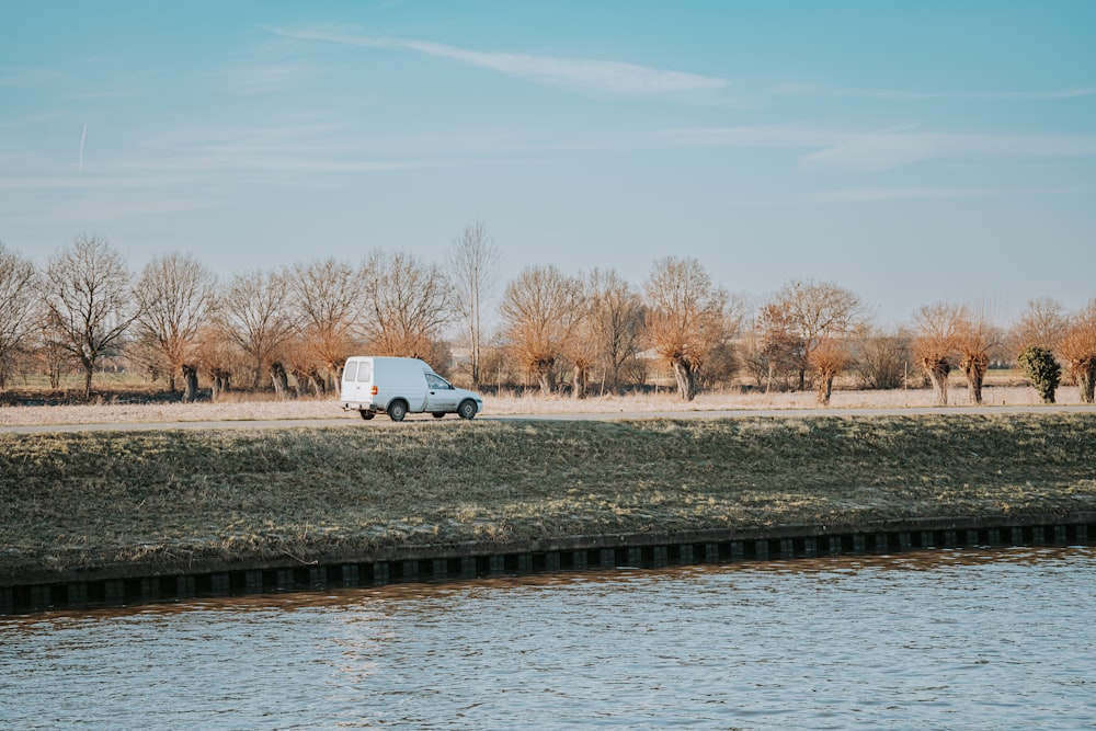 a van is parked next to a body of water