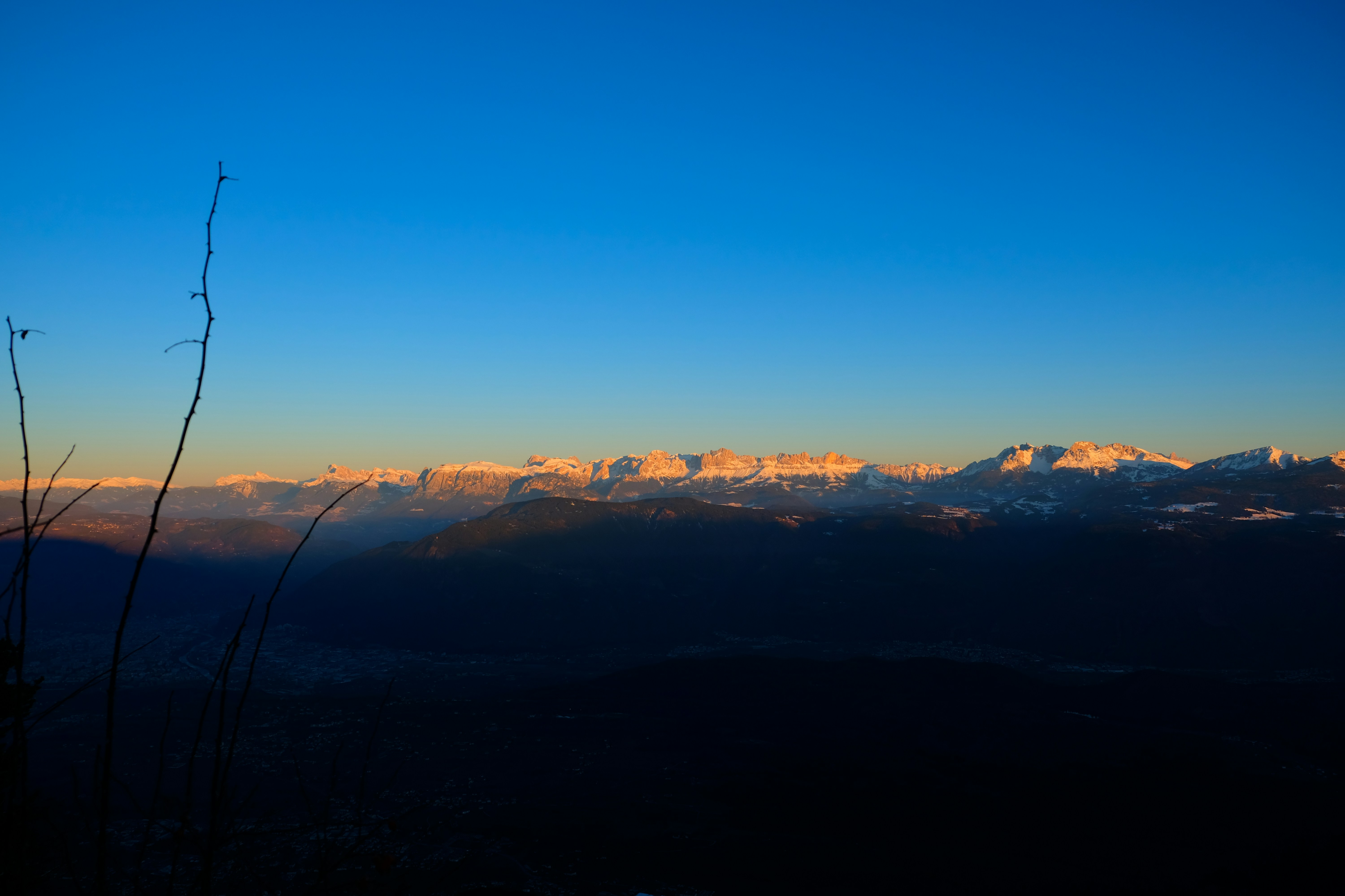 Snow-capped Himalayan peaks at sunrise with dramatic golden light, pristine white snow on mountain ridges, clear blue sky, breathtaking alpine landscape