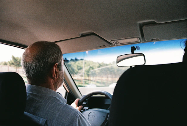 a man driving a car down a street