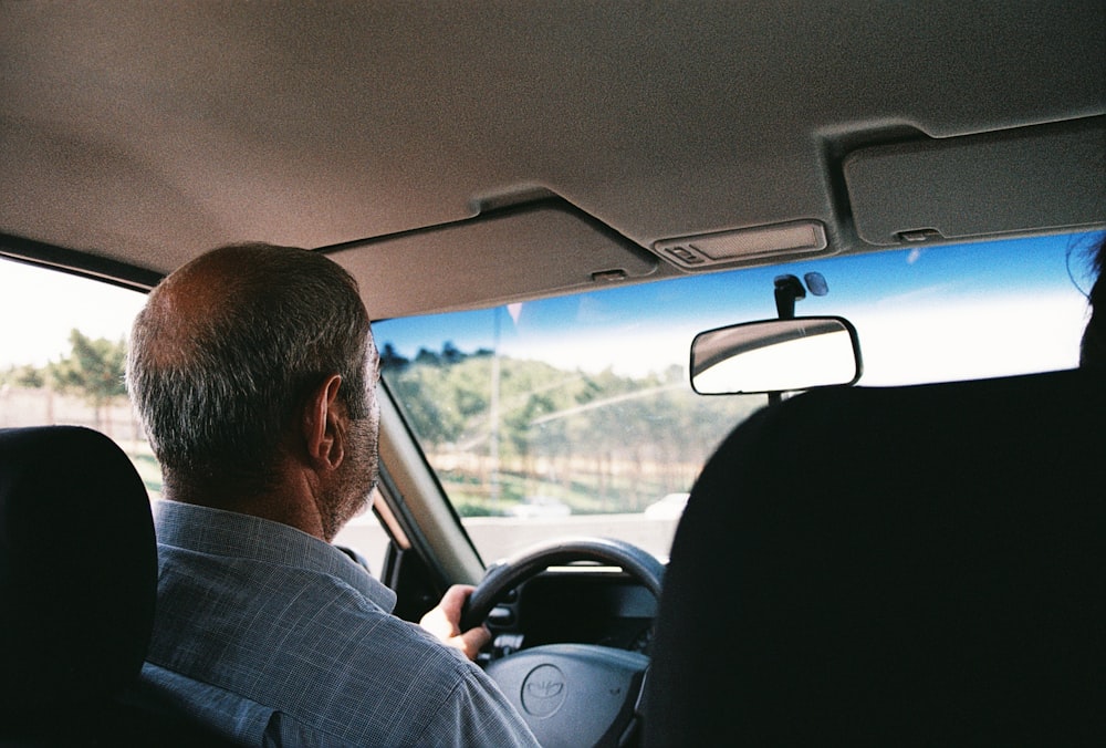 a man driving a car down a street