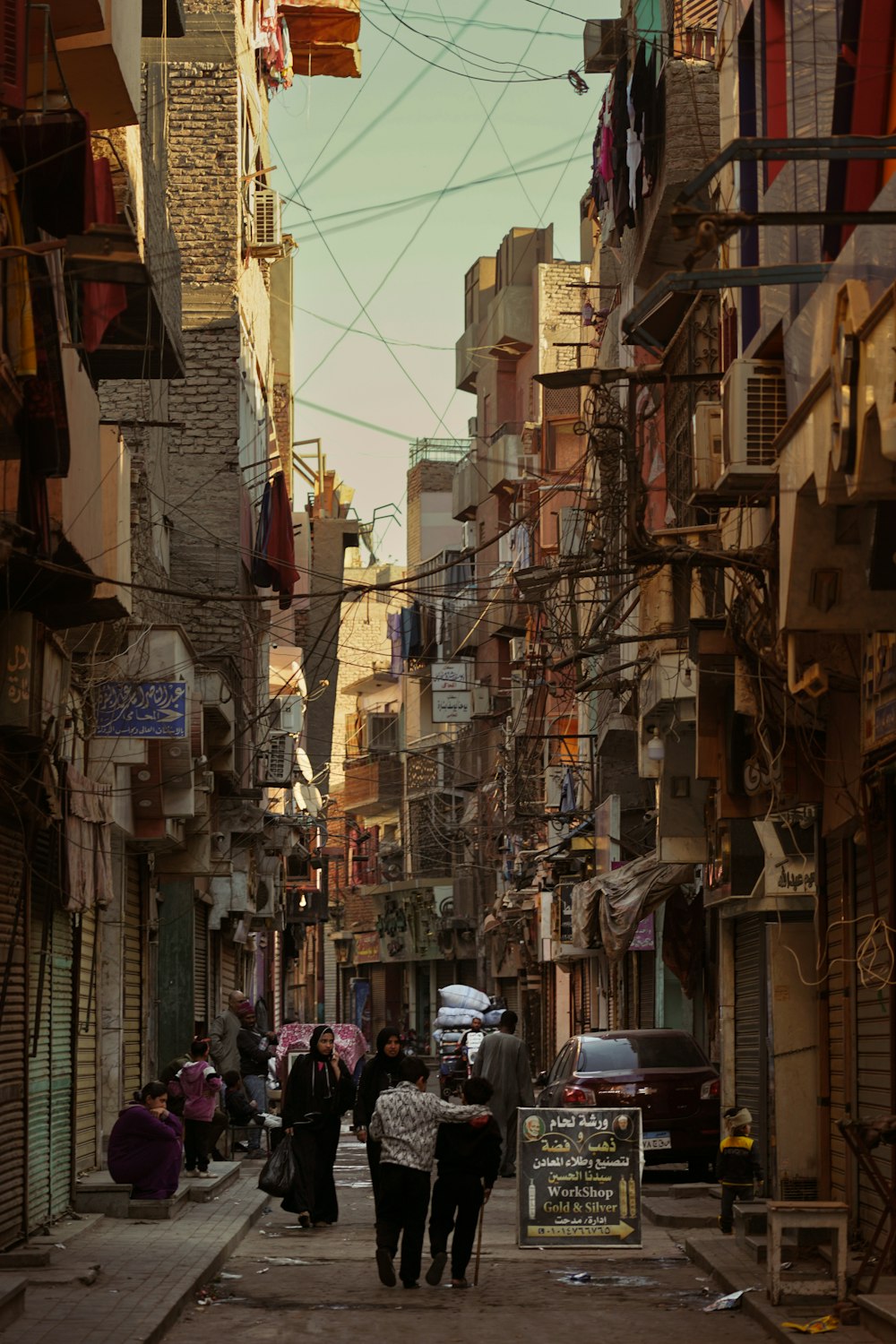 a group of people walking down a street next to tall buildings