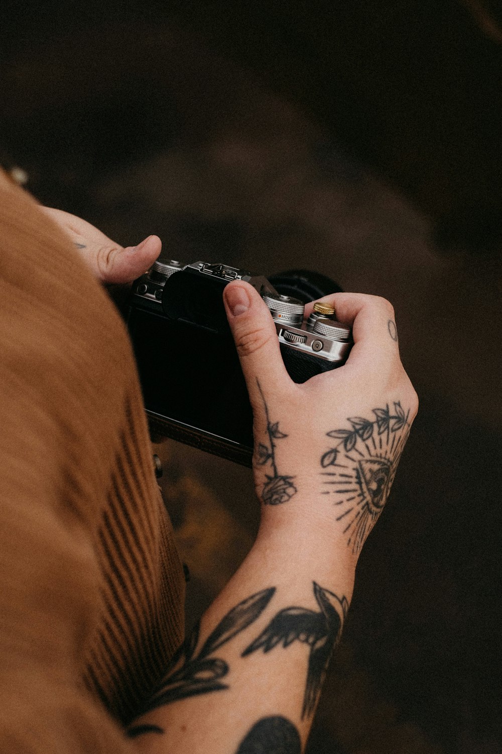 a person with a tattoo holding a camera