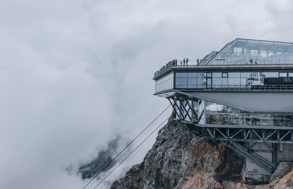 a building on top of a mountain surrounded by clouds