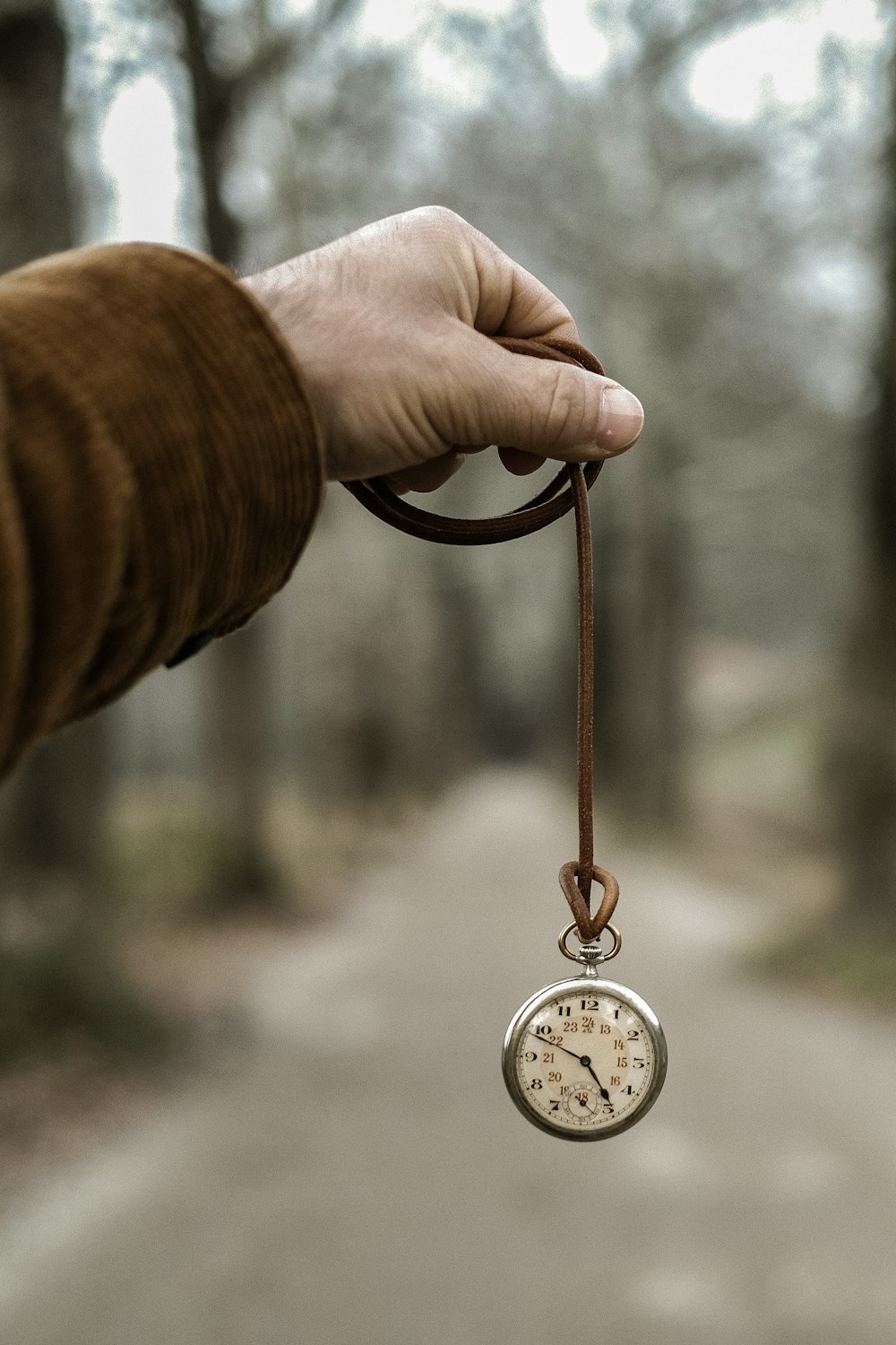 a person holding a small pocket watch in their hand