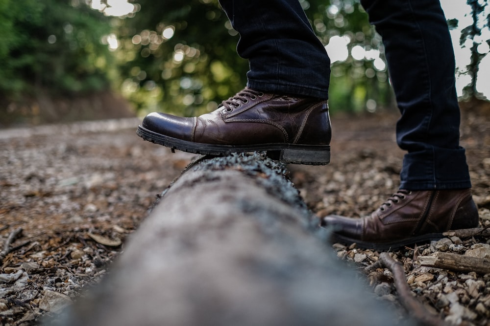 a person standing on a log in the woods