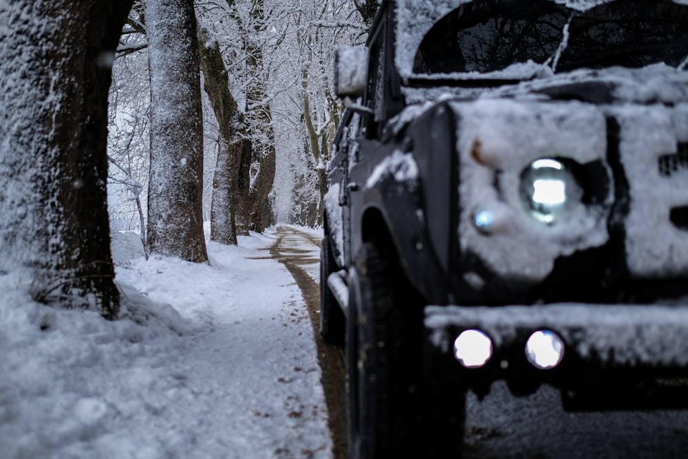 a jeep driving down a snow covered road