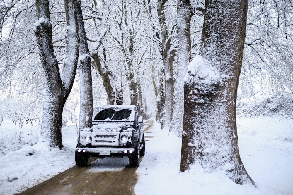 a truck driving down a snow covered road