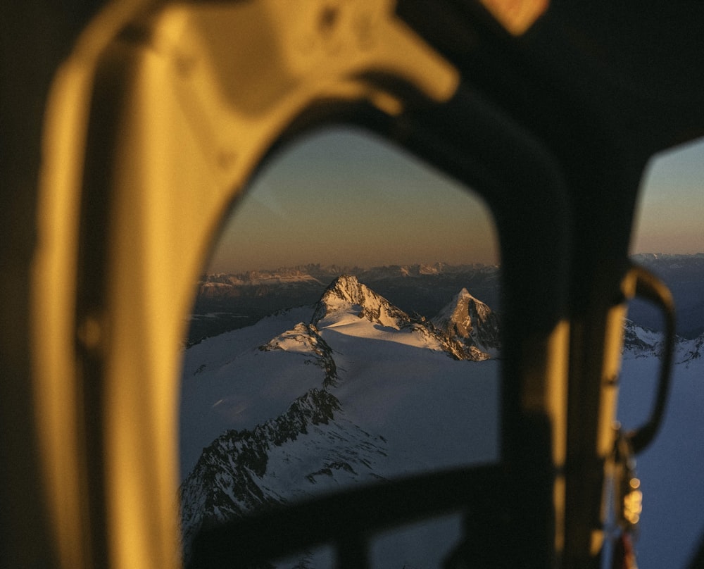 a view of a snowy mountain from inside a helicopter