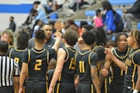 a group of young men standing next to each other on a basketball court
