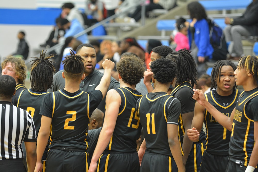 a group of young men standing next to each other on a basketball court