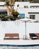 a couple of lounge chairs sitting next to a swimming pool