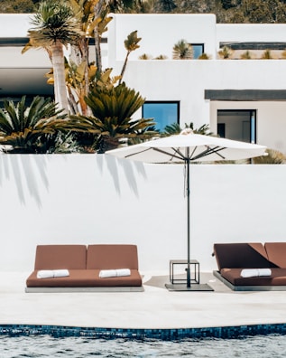 a couple of lounge chairs sitting next to a swimming pool