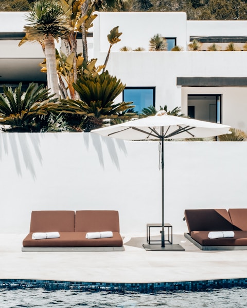 a couple of lounge chairs sitting next to a swimming pool