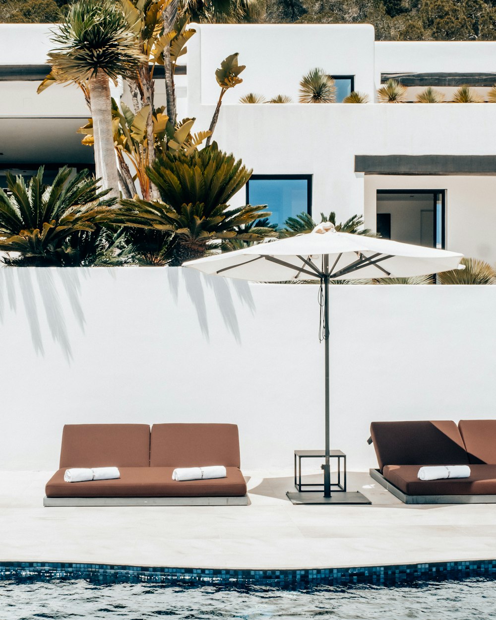 a couple of lounge chairs sitting next to a swimming pool