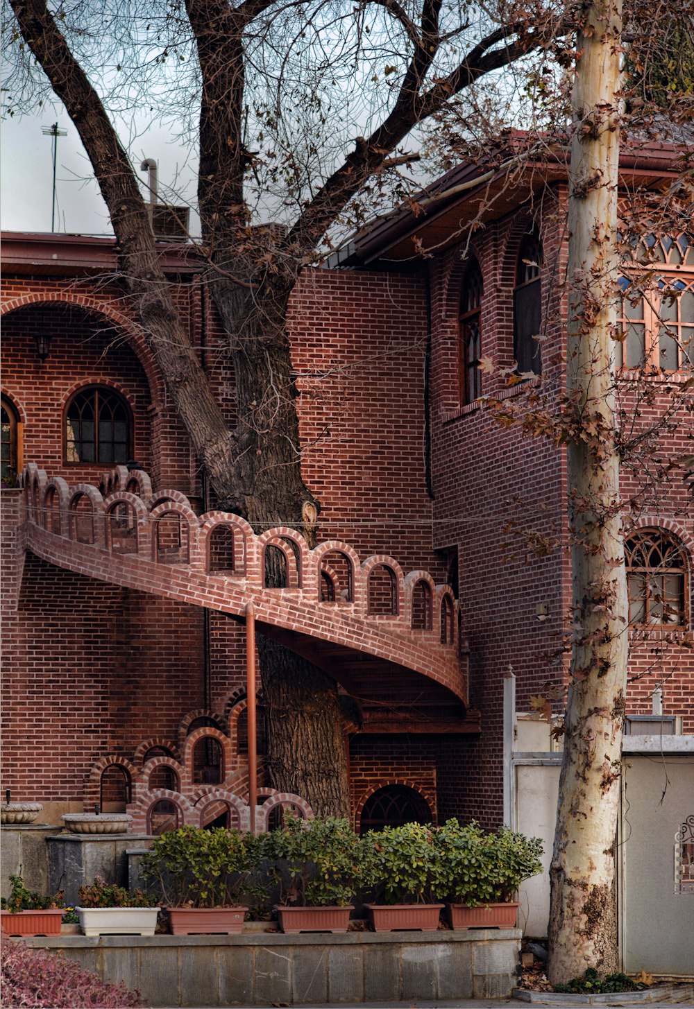 a large brick building with a tree in front of it