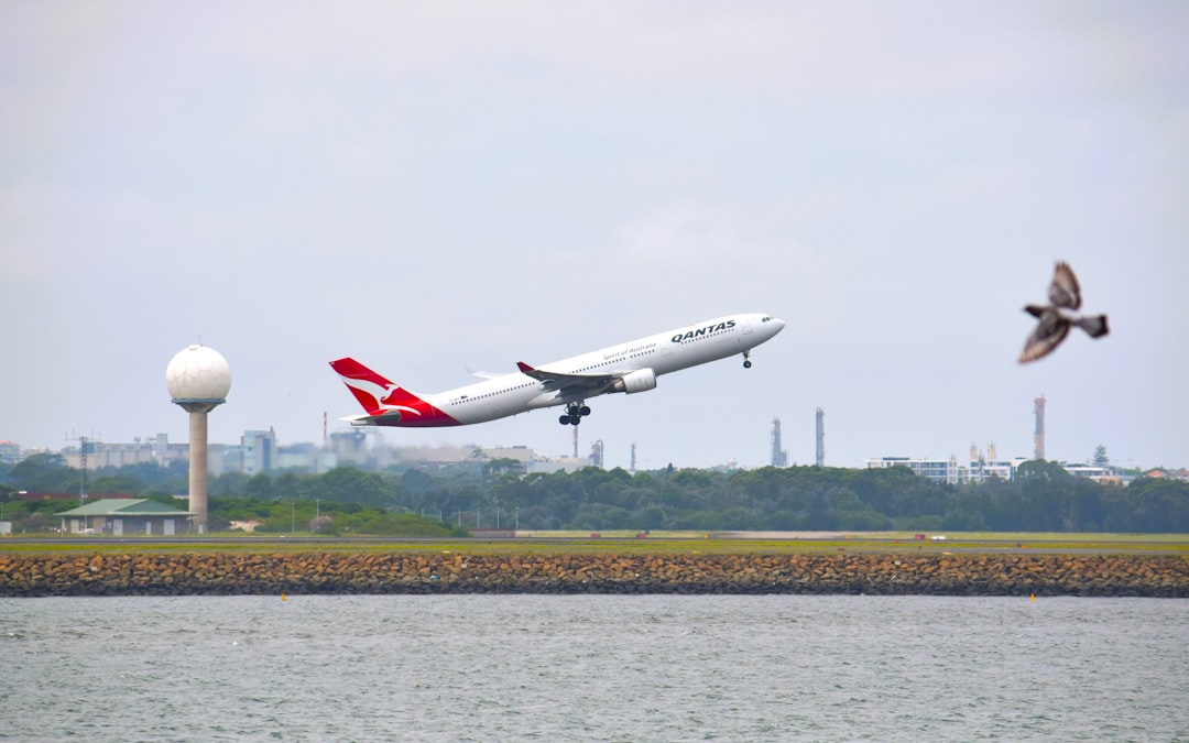 a large jetliner flying over a body of water,