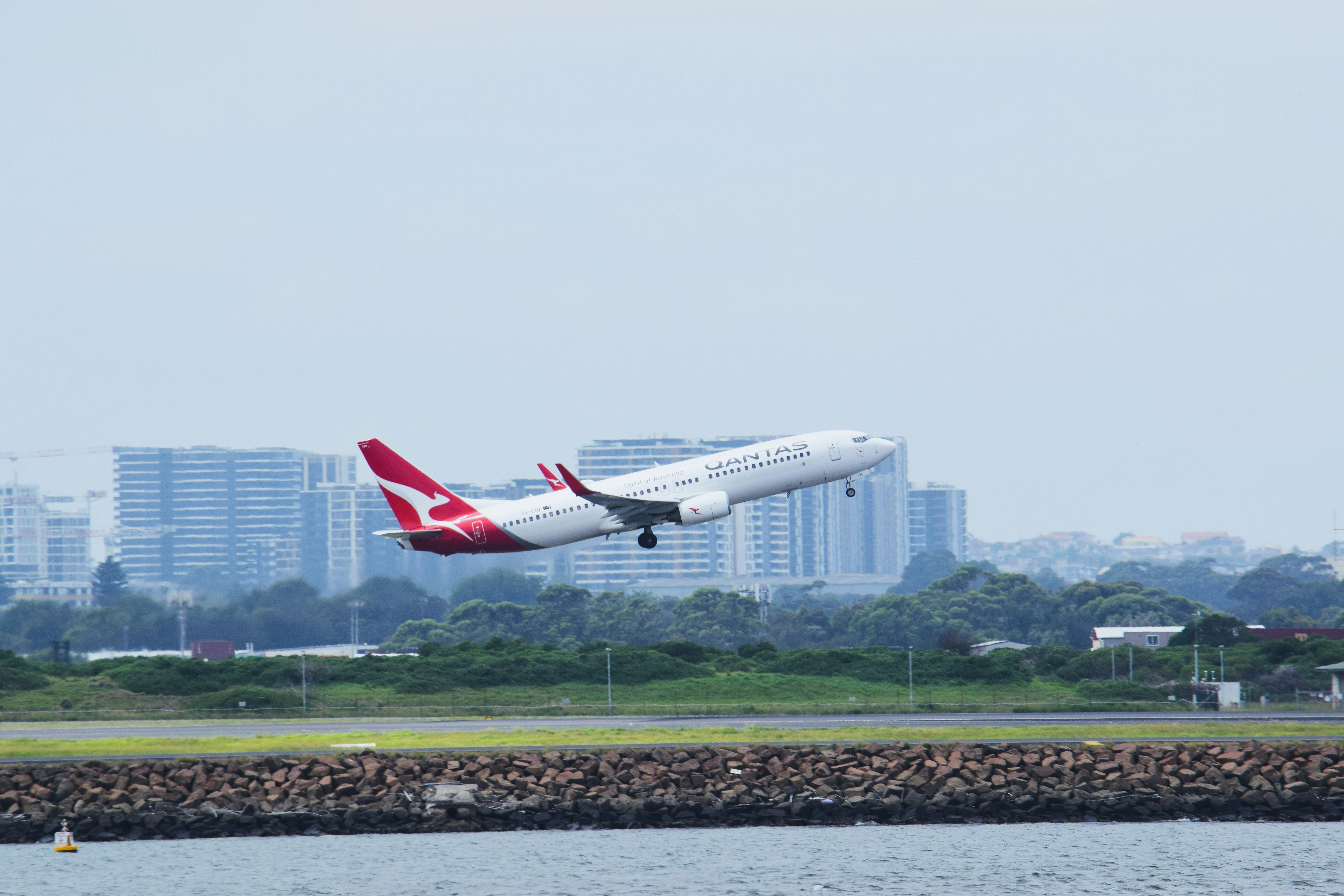 a large jetliner flying over a body of water, 