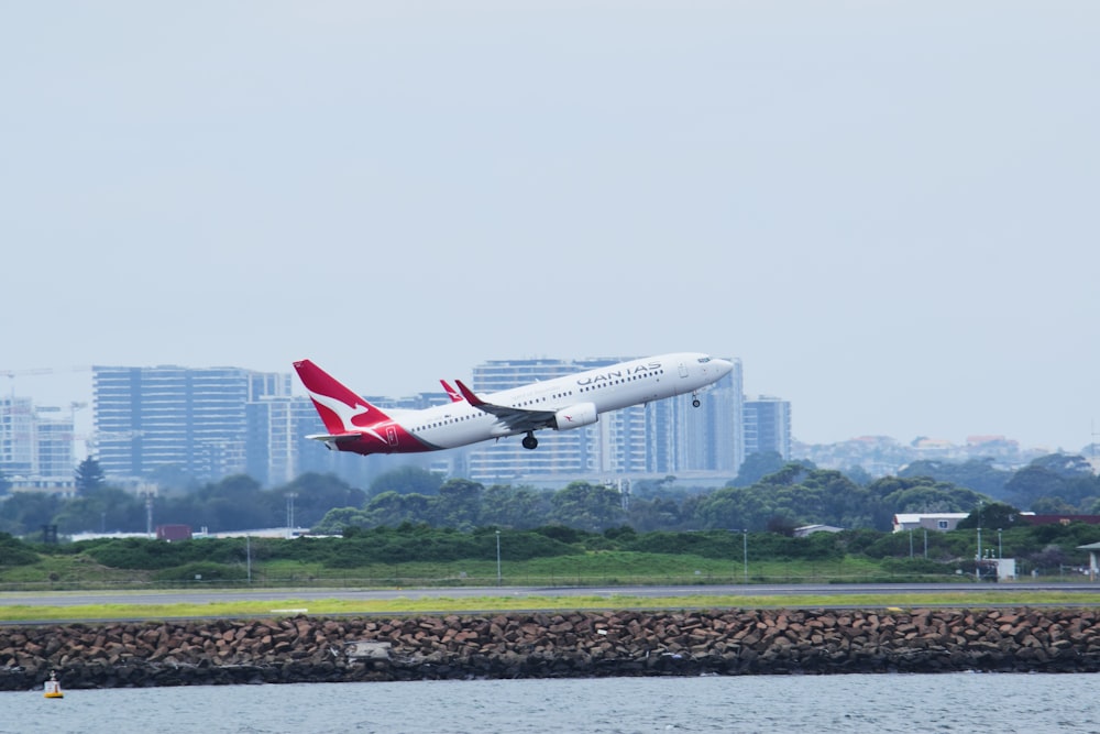 a large jetliner flying over a body of water