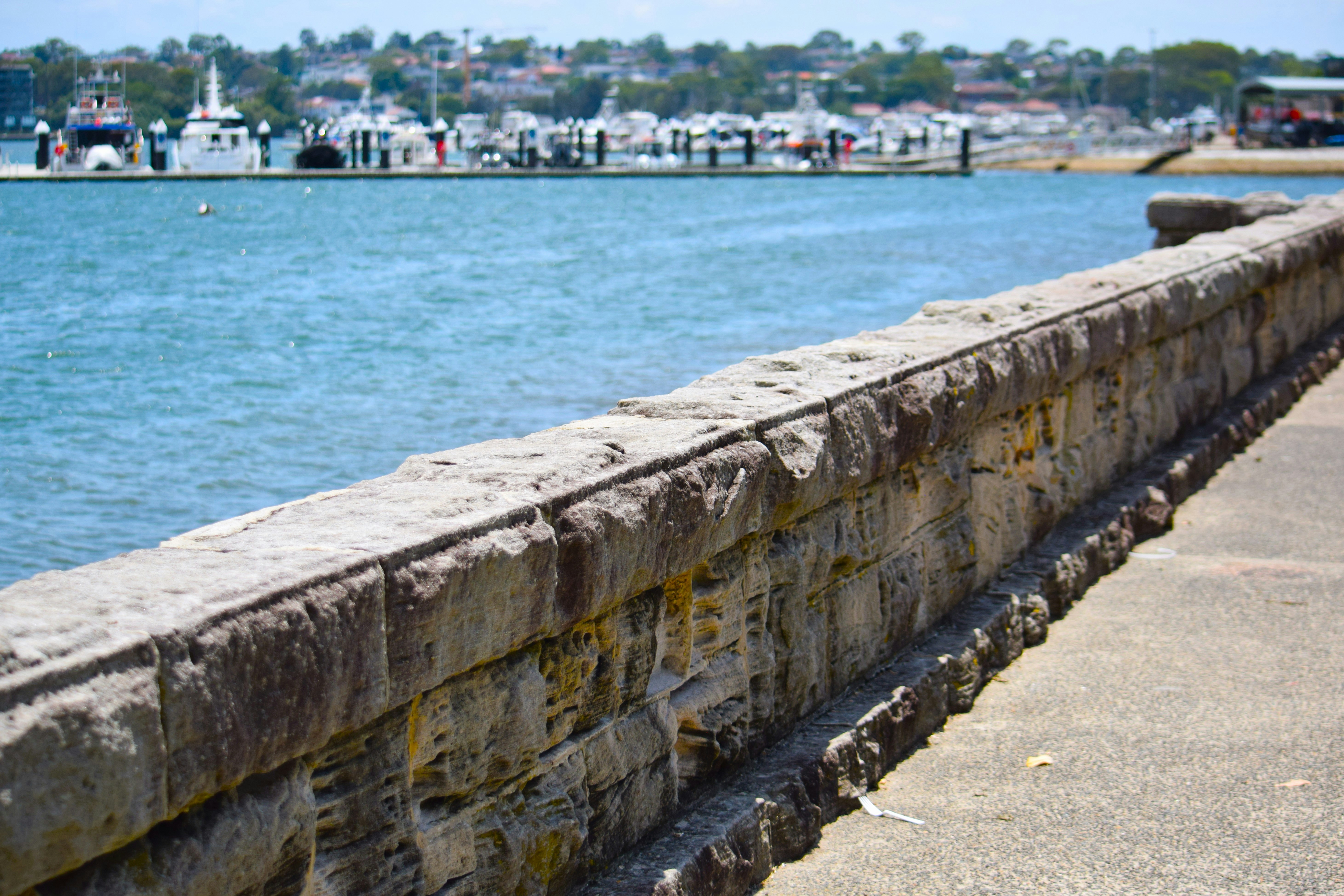 a stone wall next to a body of water