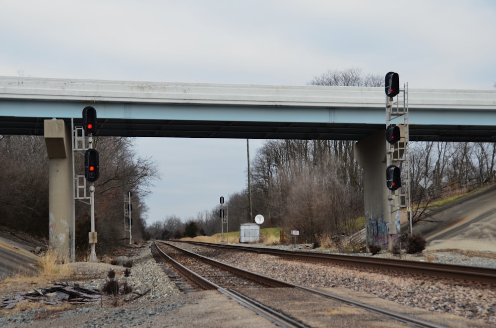 a train track under a bridge with a red light