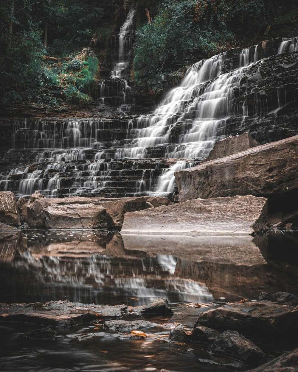 a large waterfall with a small waterfall in the middle of it