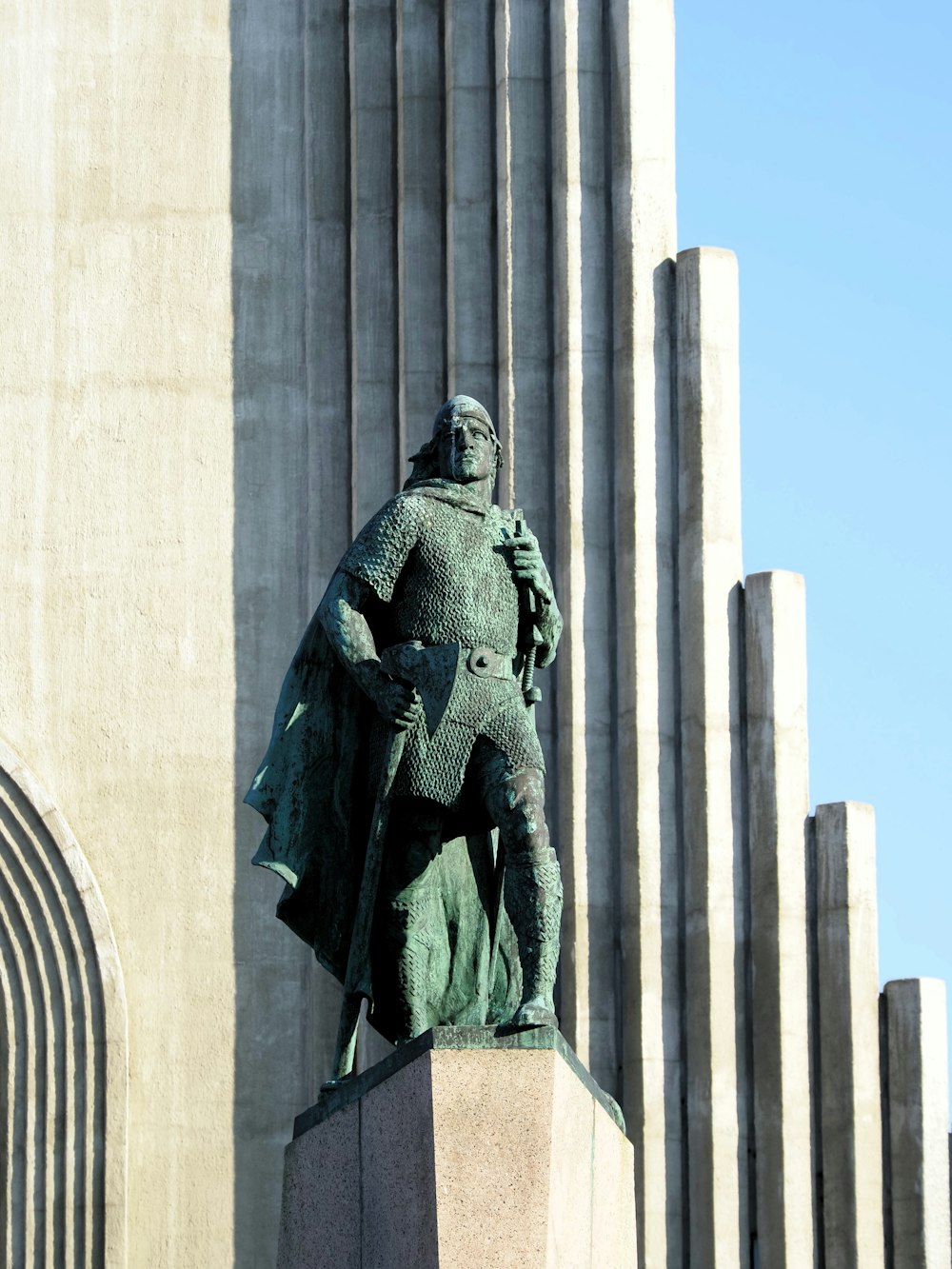 a statue of a man holding a cane in front of a building