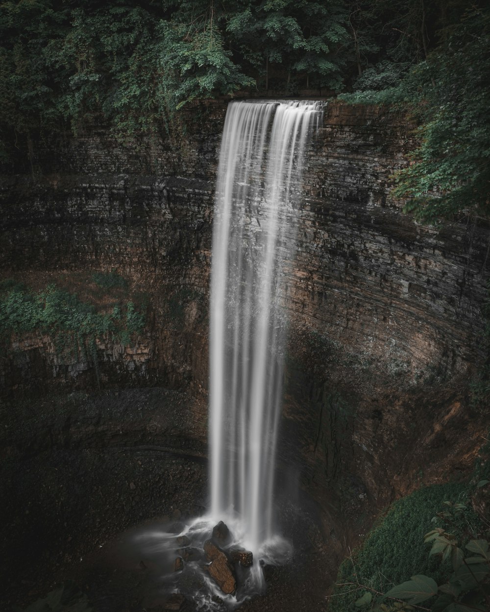 a large waterfall in the middle of a forest