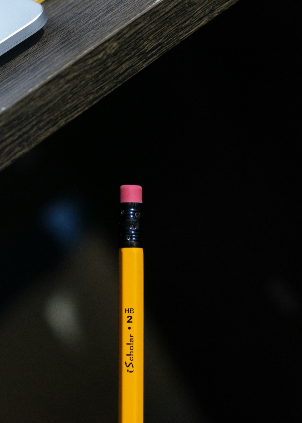 a yellow pencil sitting on top of a wooden table