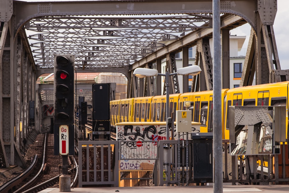 a yellow train traveling down train tracks next to a traffic light