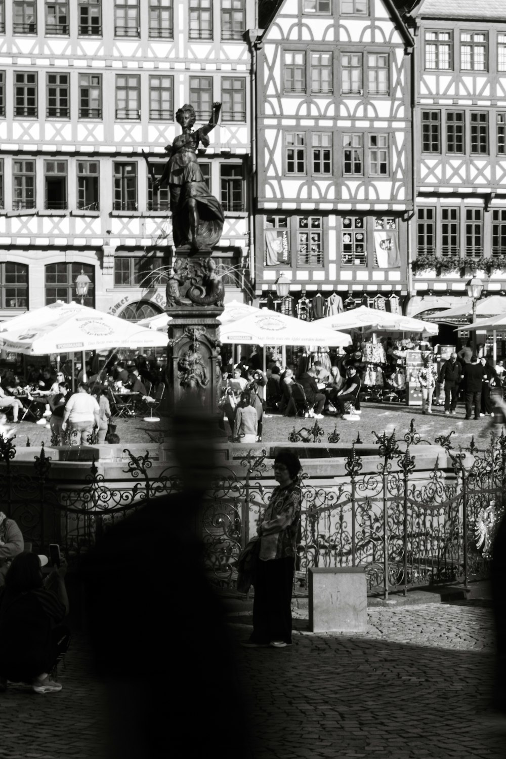 a crowd of people standing around a fountain
