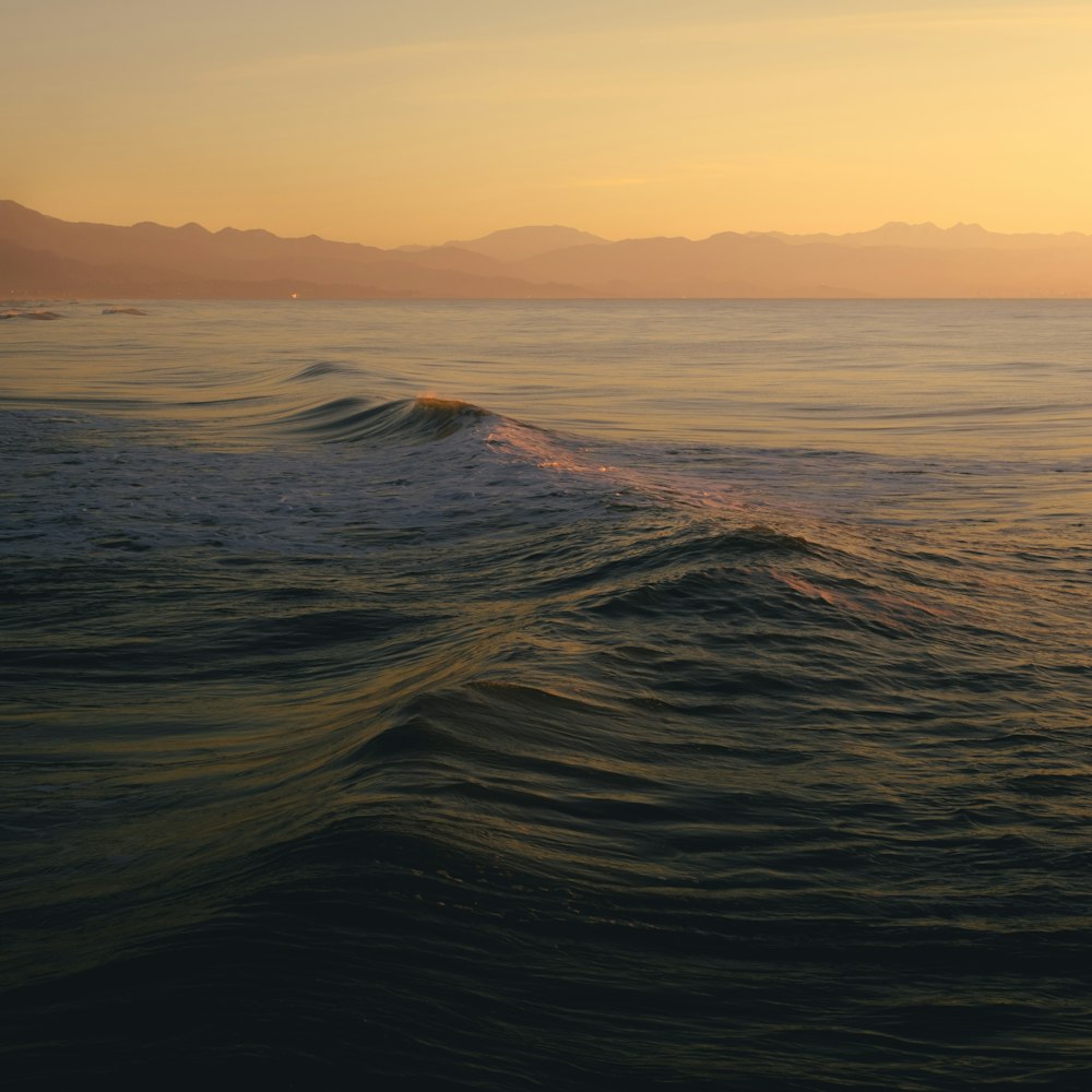 a large body of water with mountains in the background