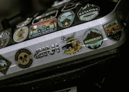 a close up of a metal object with many stickers on it