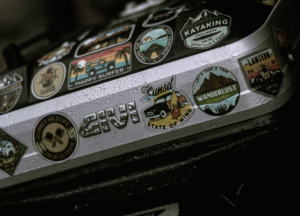 a close up of a metal object with many stickers on it