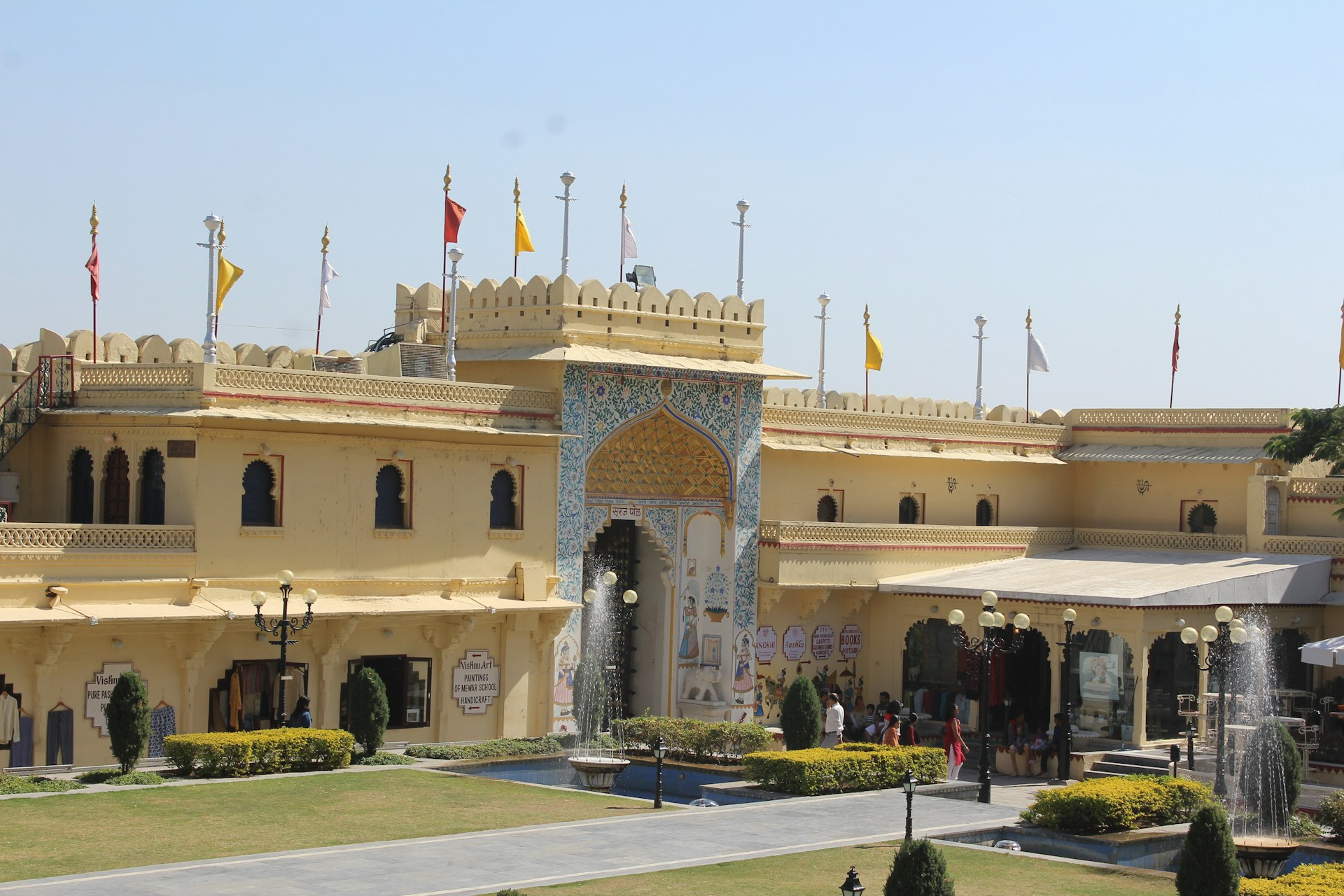 a yellow building with a fountain in front of it