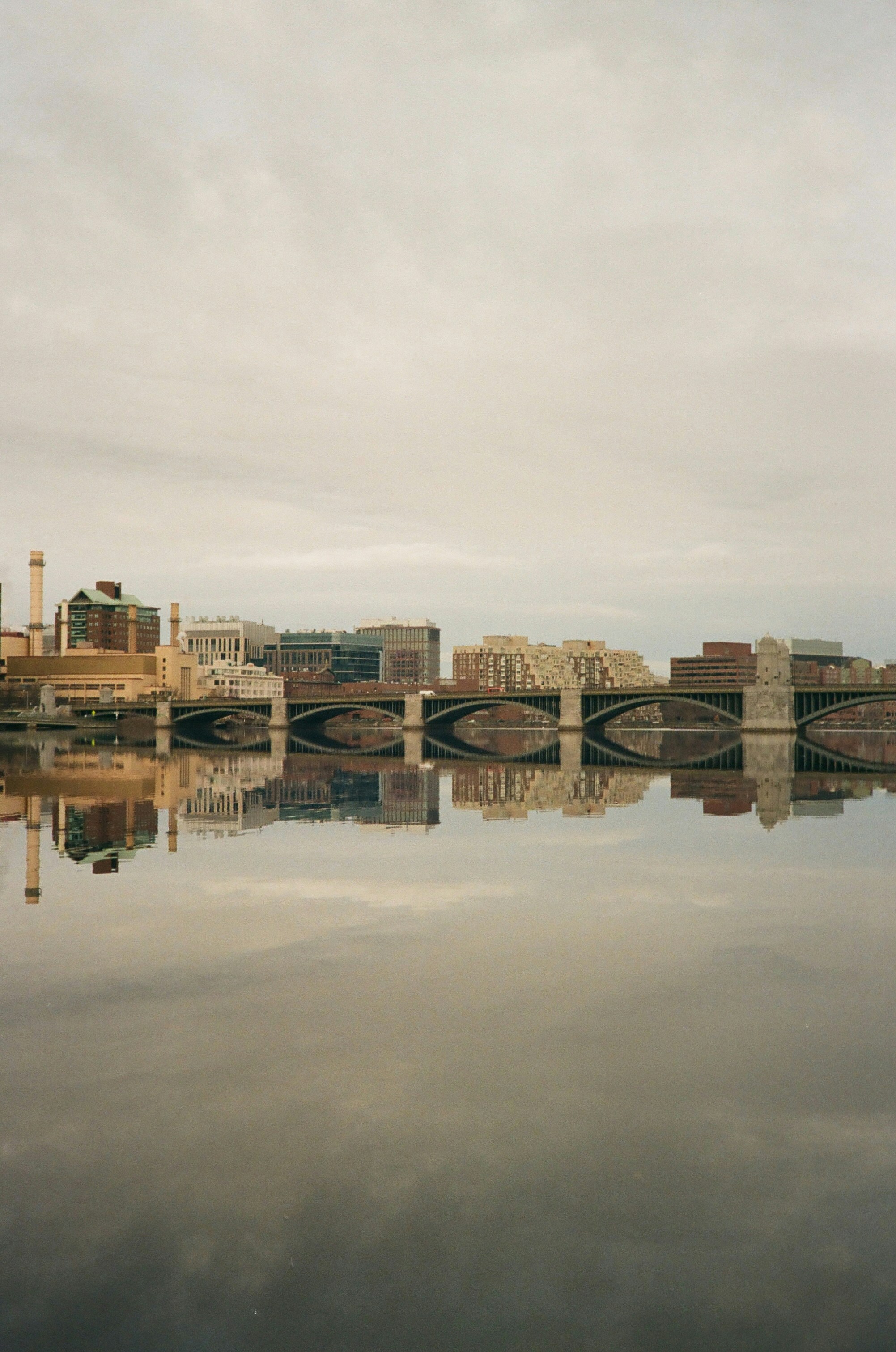A bridge over a body of water with buildings in the background photo ...