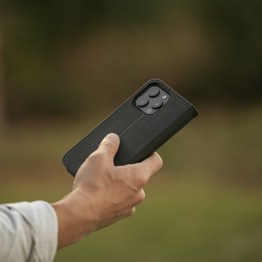 a person holding a black case in their hand