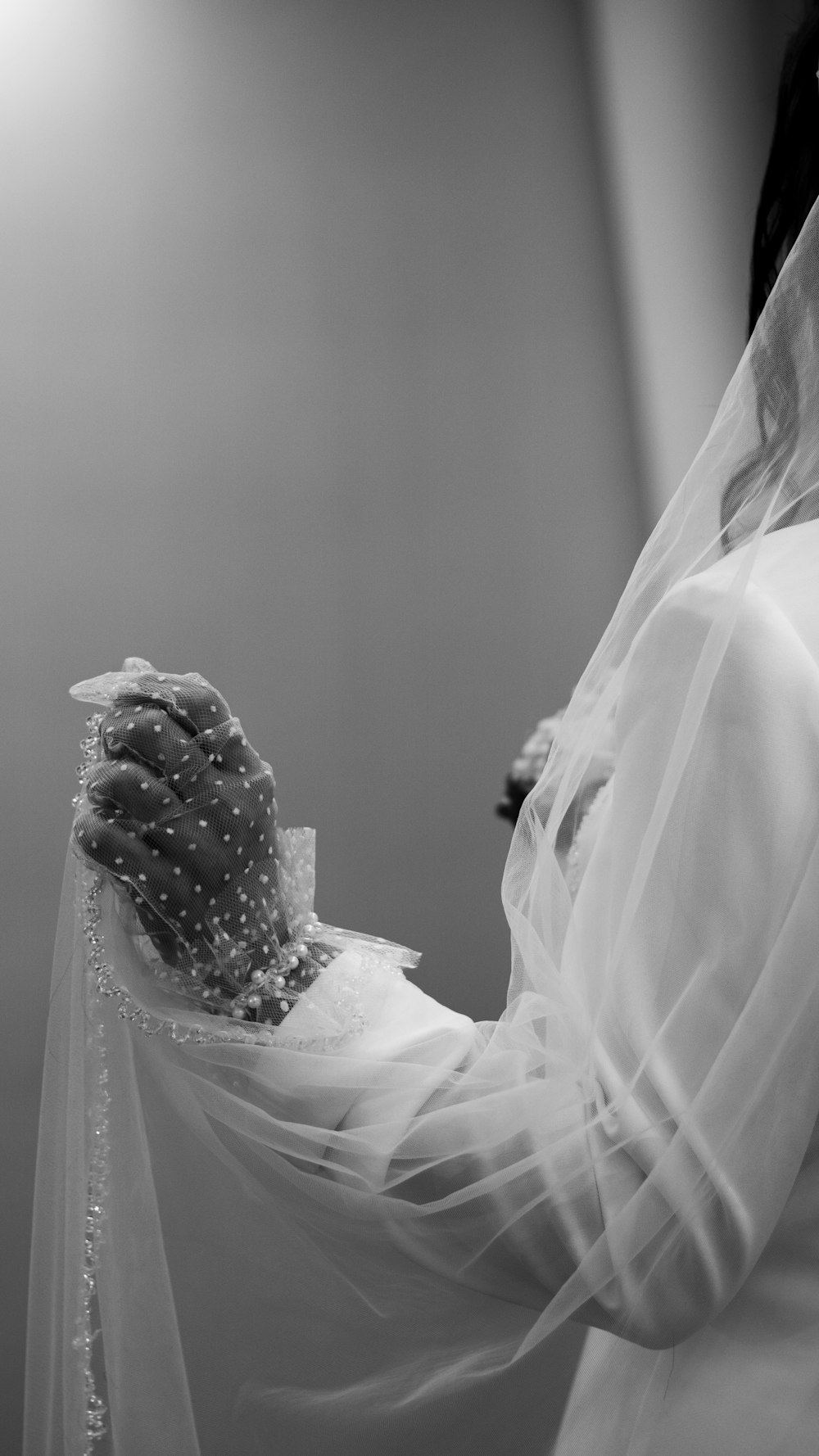 a woman wearing a veil and holding a wedding dress
