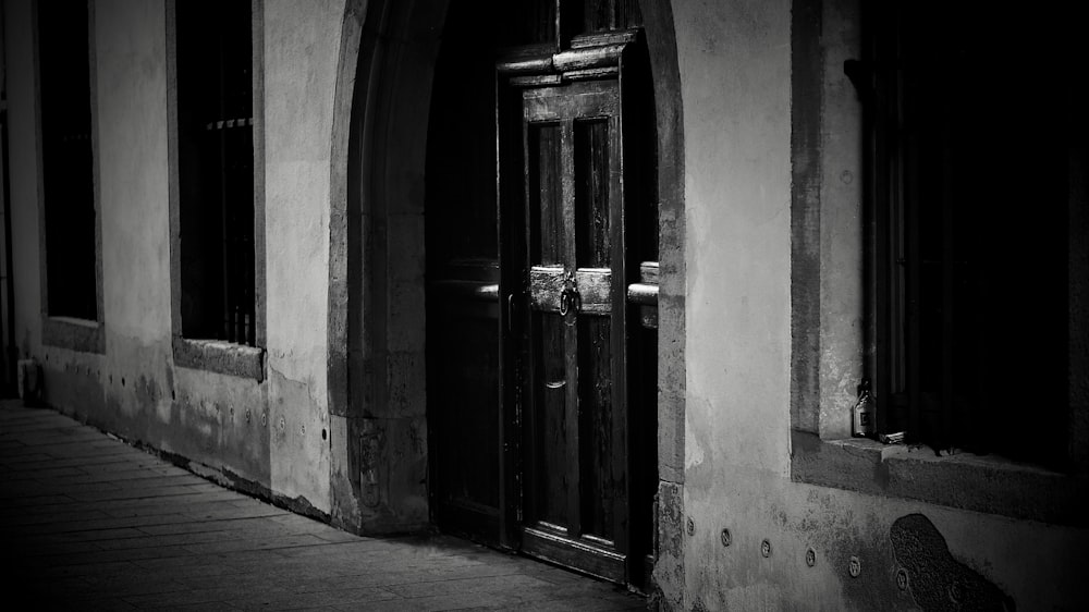 a black and white photo of a door and windows