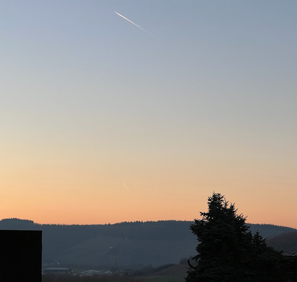 a plane is flying in the sky at sunset