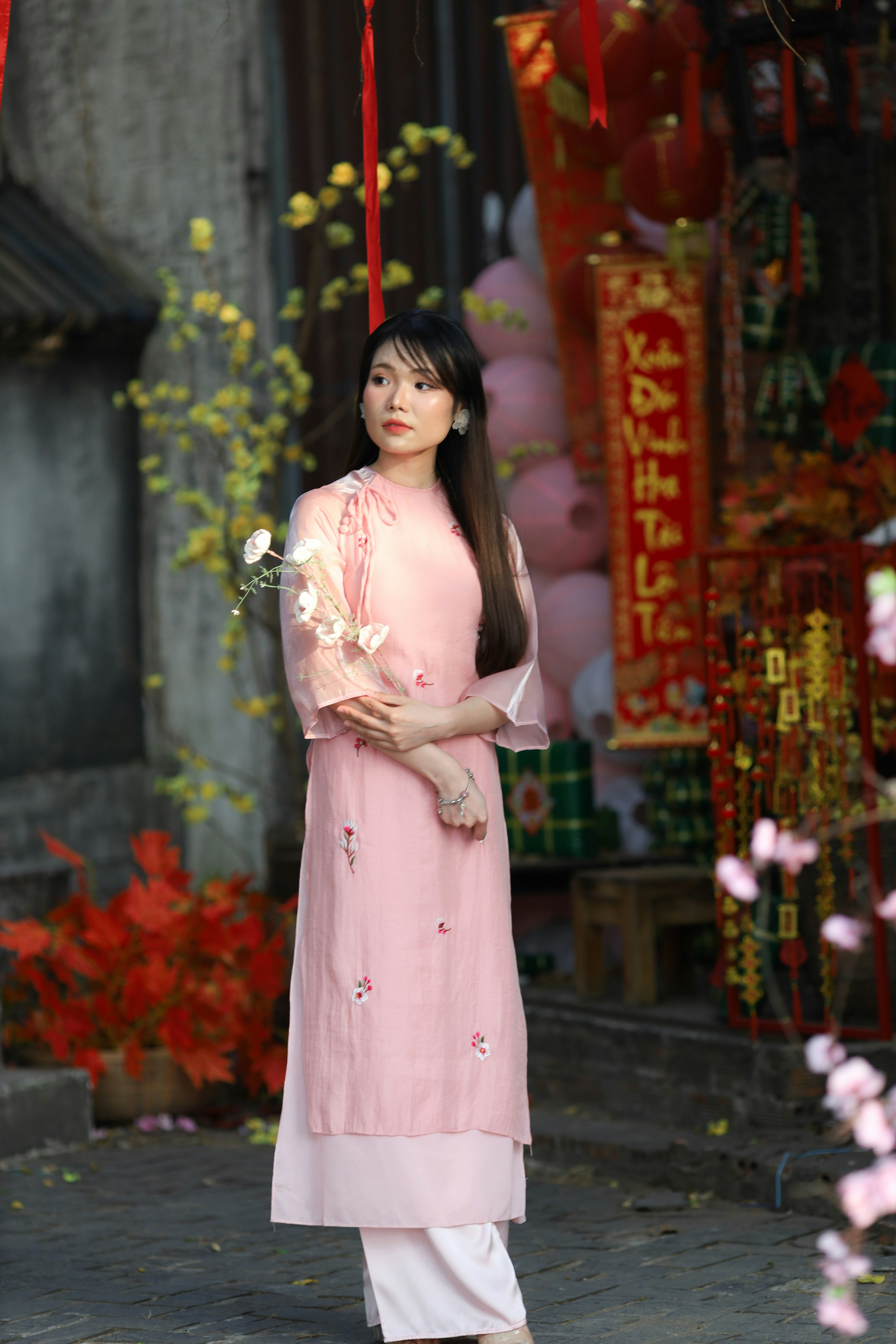 a woman in a pink dress standing under an umbrella