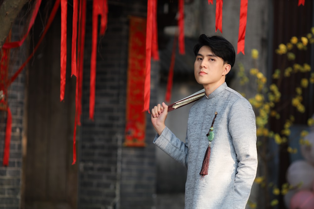 a young man holding a bamboo stick in his hand