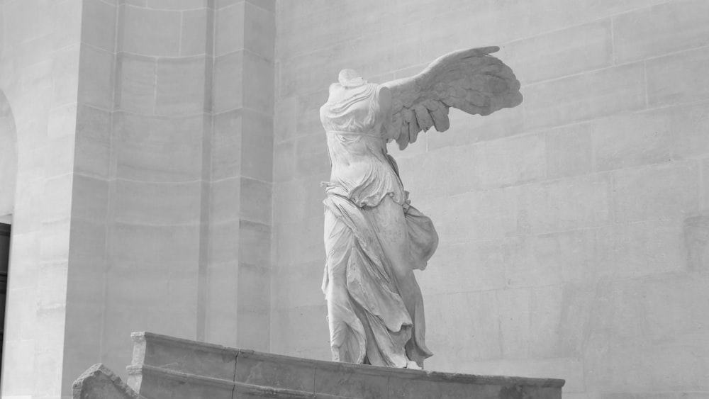 une statue d’une femme avec des ailes dans un bâtiment