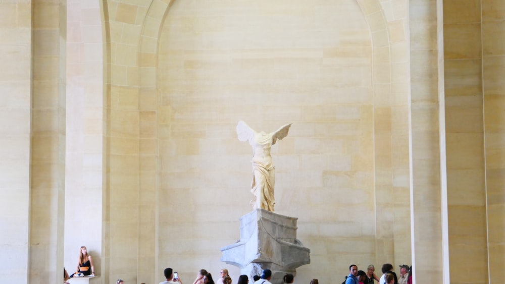 un groupe de personnes debout autour d’une statue